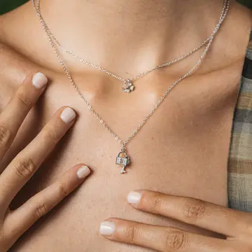 Detta vackra silverhalsband är ett unikt stycke som du inte kan missa. Med en elegant och sofistikerad design har detta halsband nyckel- och hänglåsmotiv, vilket gör det perfekt för dem som letar efter ett tillbehör med en touch av mystik och romantik.
